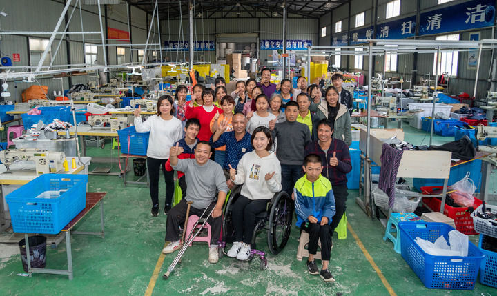 2020年10月13日,在湖南省邵阳市城步县湖南七七科技股份有限公司生产车间,杨淑亭(前排中)与工友合影。新华社记者 才扬 摄