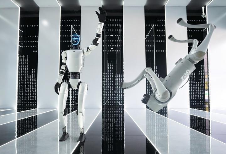 在杭州宇树科技有限公司的产品展示中心,人形机器人和四足机器人在工作人员控制下做动作。新华社记者 翁忻旸 摄