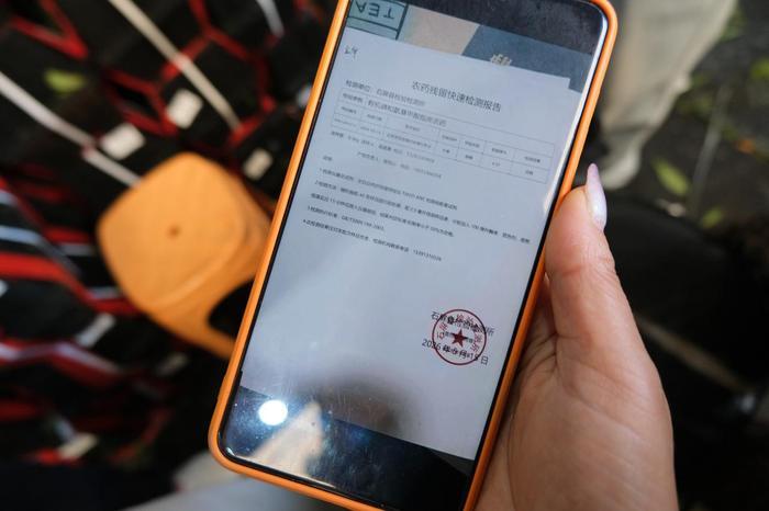 温州市场里的杨梅商户出示检测报告。受访者供图